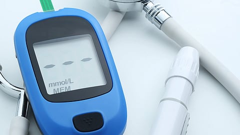 A stethoscope, blood pressure cuff, and glucose meter arranged on a table.