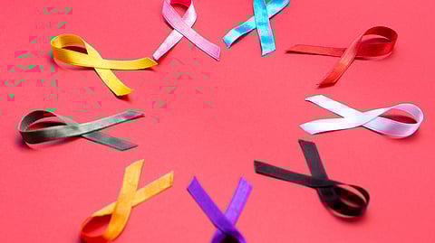 A circle of vibrant colored ribbons arranged on a bright red background.