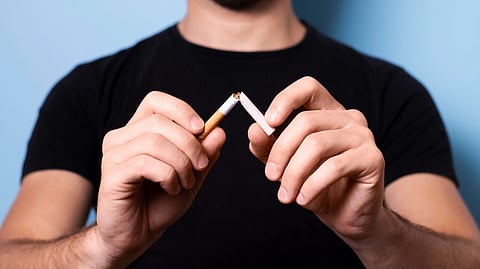 A man holding a cigarette between his fingers.