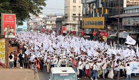 A large group of protestors with white flags and placards. 