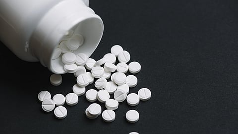 White pills falling out of bottle