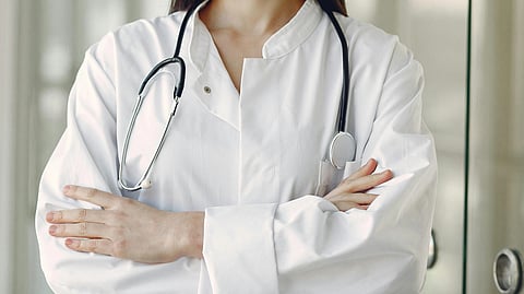 A doctor in white coat and stethoscope around neck.