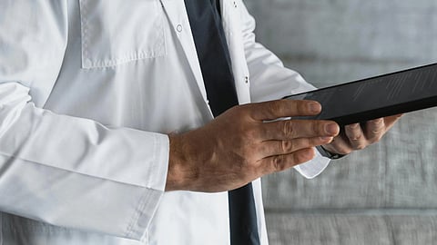 A doctor holding a tablet.