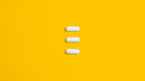 Yellow background, white capsules.