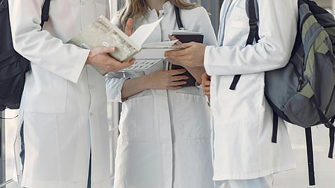 3 medical students standing in a group.