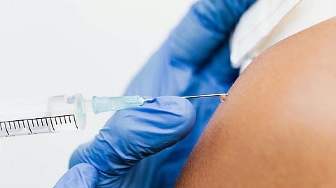 An injection being administered on someone's arm.