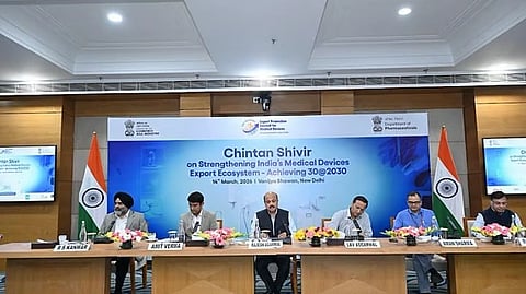 Chintan Shivir conference, people sitting on stage with Indian Flag Behind.