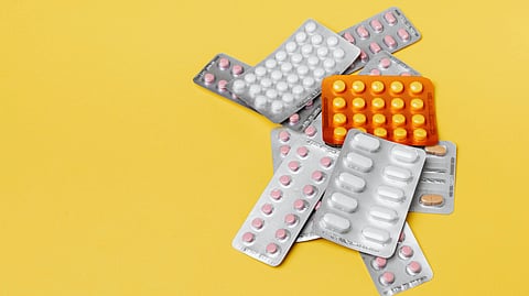 A bunch of medicine strip kept on yellow background.