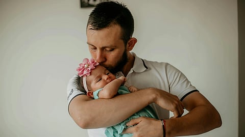 A dad holding his baby girl.
