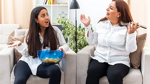 Two women in a cozy living room passionately discussing something. 