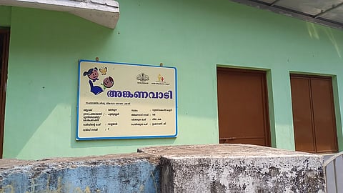 An Anganwadi board in Kerala written in Malayalam in front of the building.