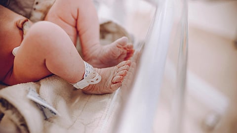 A baby's legs with hospital tag.