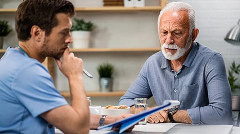 An elderly man listens to his doctor during a check-up.