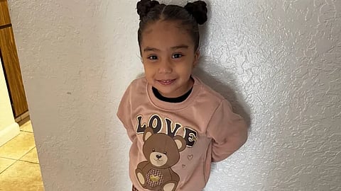 A picture of Camila standing against a wall. 