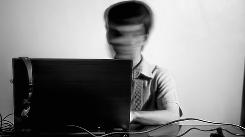 a blurry image of a man using a laptop computer