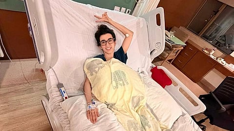 Actor Saba Azad lying in a hospital bed, posing for the camera