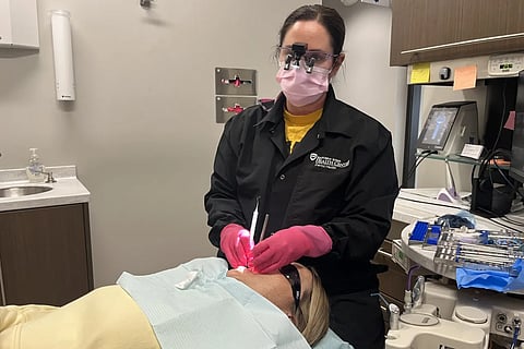 Dental hygienist Lexi Rusnak cleans a patient’s teeth at the Eastern Iowa Health Center in Cedar Rapids, Iowa, on March 26.