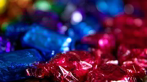 A close-up of colorful candies wrapped in shiny foil, featuring vibrant blues and reds.