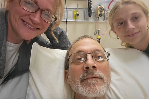 Eric Tennant on the hospital bed, clicked photo with his wife, Becky, and daughter, Amiya (Becky Tennant)