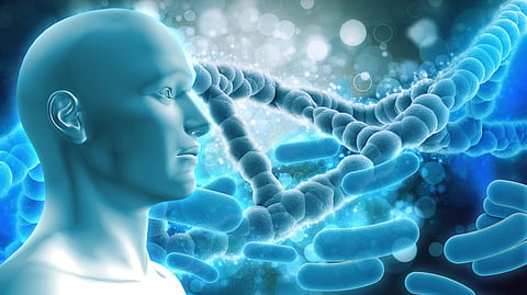 A blue-toned 3D human figure is beside a large DNA strand and bacteria.