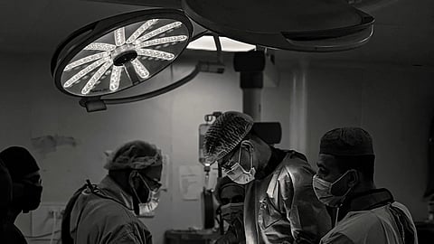 3 surgeons during surgery, black and white picture.