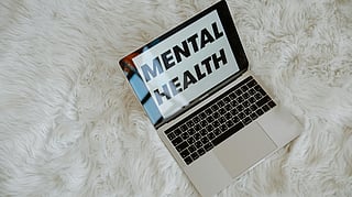A laptop kept open and on screen text of mental health.