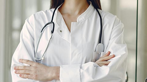 A doctor in white coat witj stethoscope around neck.