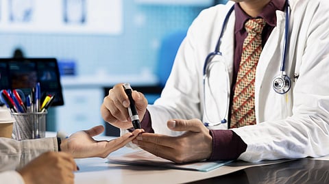 A doctor checking a patient's blood sugar levels using a glucometer.