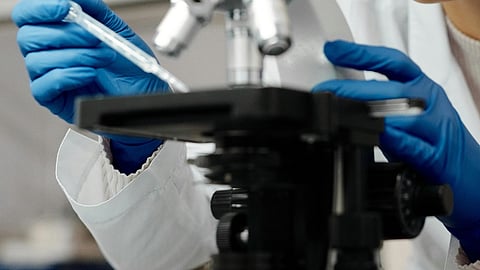 Scientist with microscope.