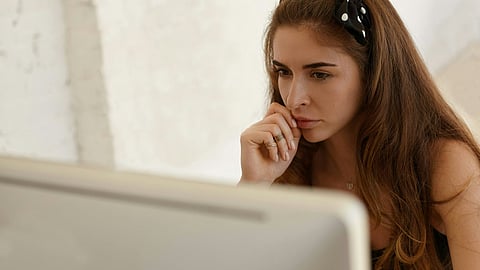 a woman sitting in front of a laptop computer