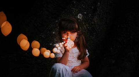 A kid holding a bulb.