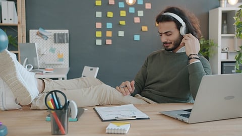 Man with headphones listening to music at desk