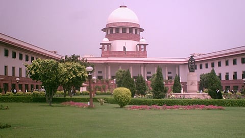Image of Supreme Court surrounded by lush greenery and symmetrical gardens.