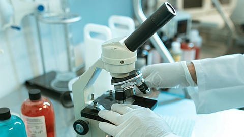 Scientist using microscope.