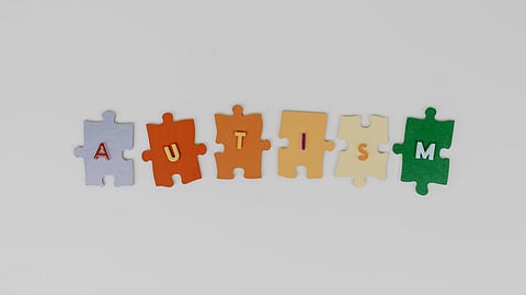 Colorful puzzle pieces spell "AUTISM," with each letter on a different piece.