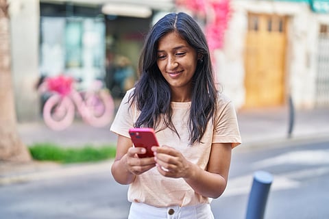 Young beautiful indian woman smiling confident using smartphone at street