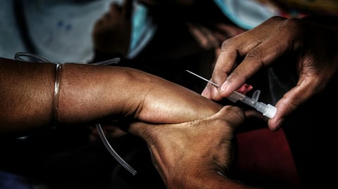 Close-up of a healthcare worker conducting a tuberculosis screening or diagnostic procedure on a patient’s arm.
