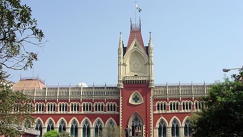 Historic red-and-cream Gothic building with arches and a clock tower.