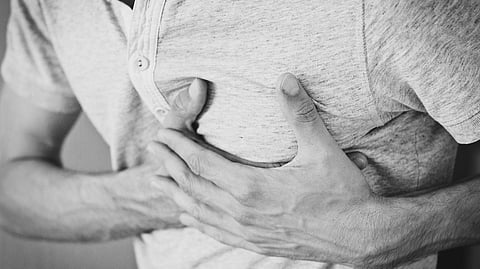 Young adult with chest pain symbolizing sudden cardiac arrest risk.