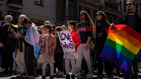 A joyful pride parade crowd celebrates love, inclusion, and equality.