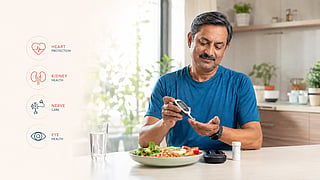A bright, modern healthcare lifestyle scene showing a middle-aged Indian adult with diabetes confidently following healthy daily habits, checking blood sugar using a glucose monitor in a sunlit kitchen.