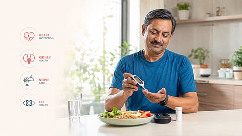A bright, modern healthcare lifestyle scene showing a middle-aged Indian adult with diabetes confidently following healthy daily habits, checking blood sugar using a glucose monitor in a sunlit kitchen.