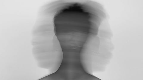 A blurred image of a man's head, creating an abstract and indistinct representation of his features.
