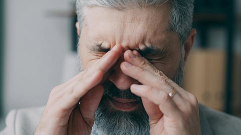 A man rubbing his eyes.