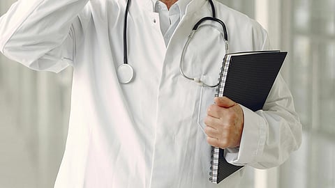 A doctor with stethoscope and holding a file.