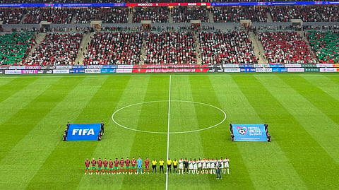 Wide-angle view of a packed football stadium during a FIFA match. 