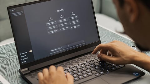 Youth using an AI chatbot on a laptop.