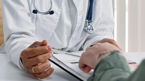 A doctor with stethoscope discussing reports with a patient, explaining the values.