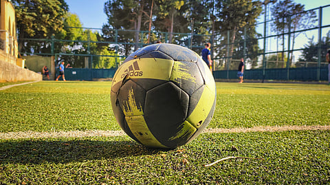 A soccer ball resting on green grass, ready for play.