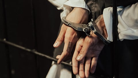 Person in handcuffs representing arrests in Bihar fake NEET UG 2026 question paper scam